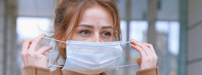 Woman putting on medical mask