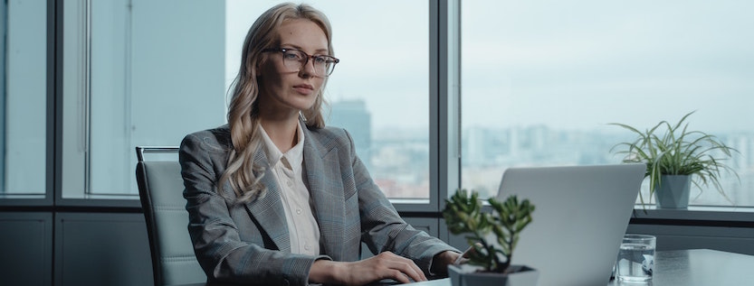 Woman in suit typing on laptop